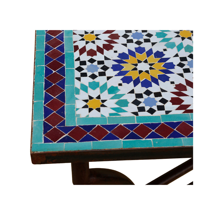 Mesa de mosaico robusta com tampo de azulejos artisticamente trabalhado e estrutura metálica curvada