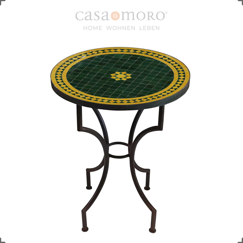 Mesa de bistrô com mosaico de zellige em verde e amarelo sobre uma estrutura curvada