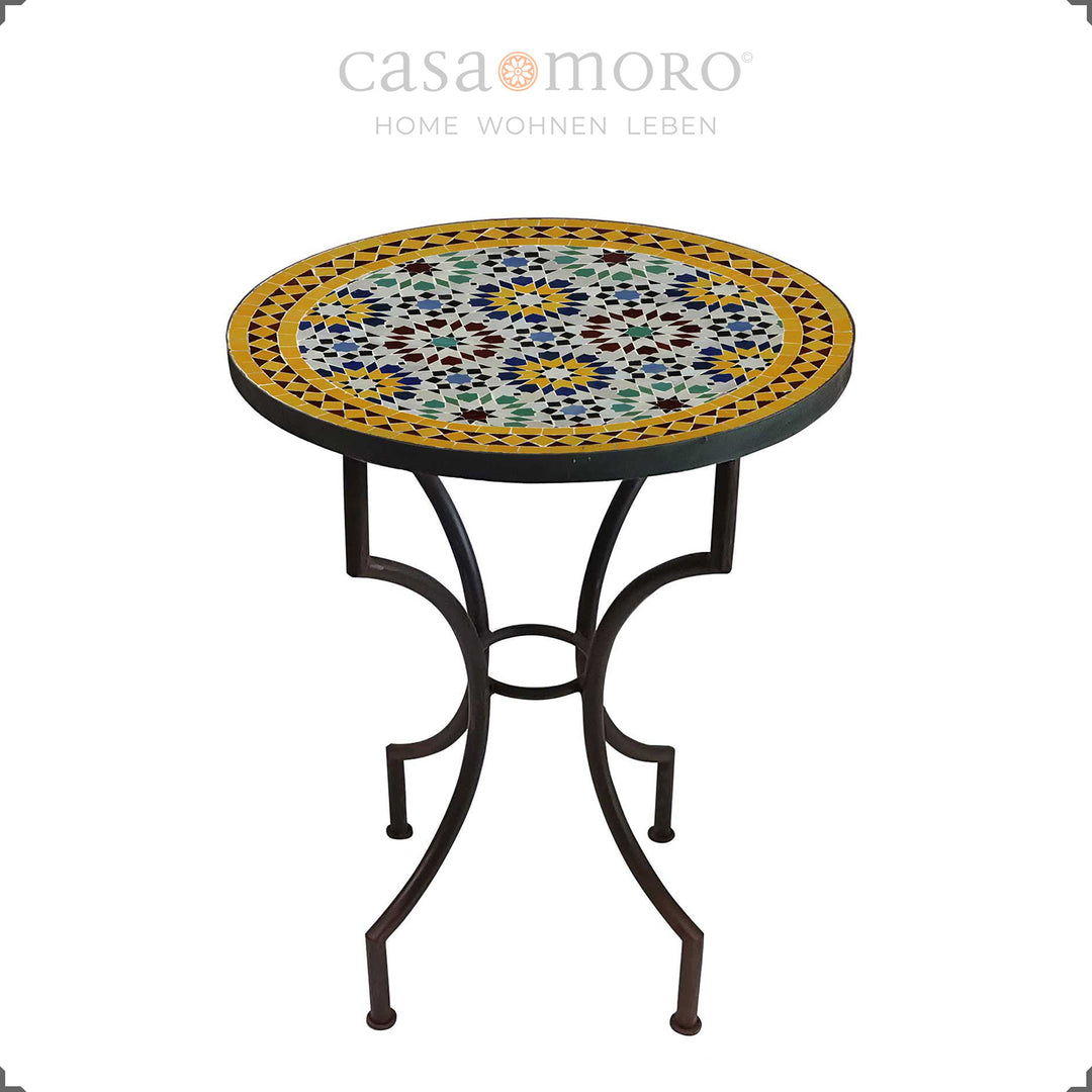 Mesa de jardim com um padrão de mosaico intenso em azul, amarelo, bordô e verde – mesa redonda para duas pessoas