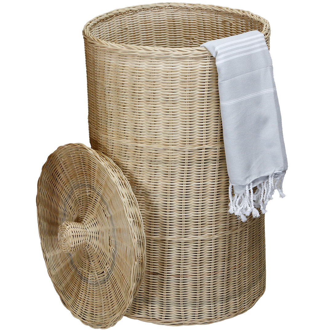 Cesto de roupa suja grande e redondo com tampa em rattan trançado, decorado com uma toalha de banho branca