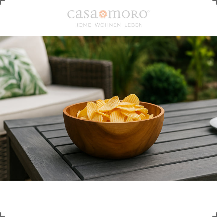 Taça decorativa com batatas fritas sobre uma mesa de jardim escura