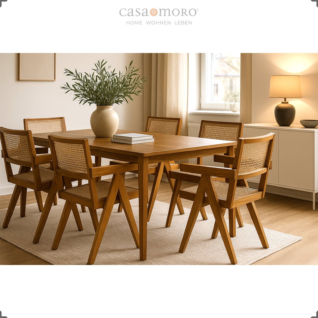 Sala de jantar com mesa em teca maciça e cadeiras com braços a condizer, com encosto em vime vienense, num ambiente acolhedor em tons naturais