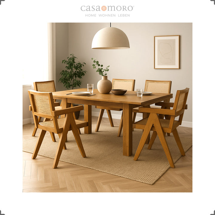 Sala de jantar com mesa em teca e cadeiras com braços em vime vienense, interior harmonioso em tons naturais