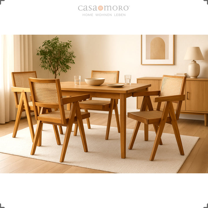 Sala de jantar com quatro cadeiras com braços em teca e vime vienense, um arranjo harmonioso em tons naturais quentes