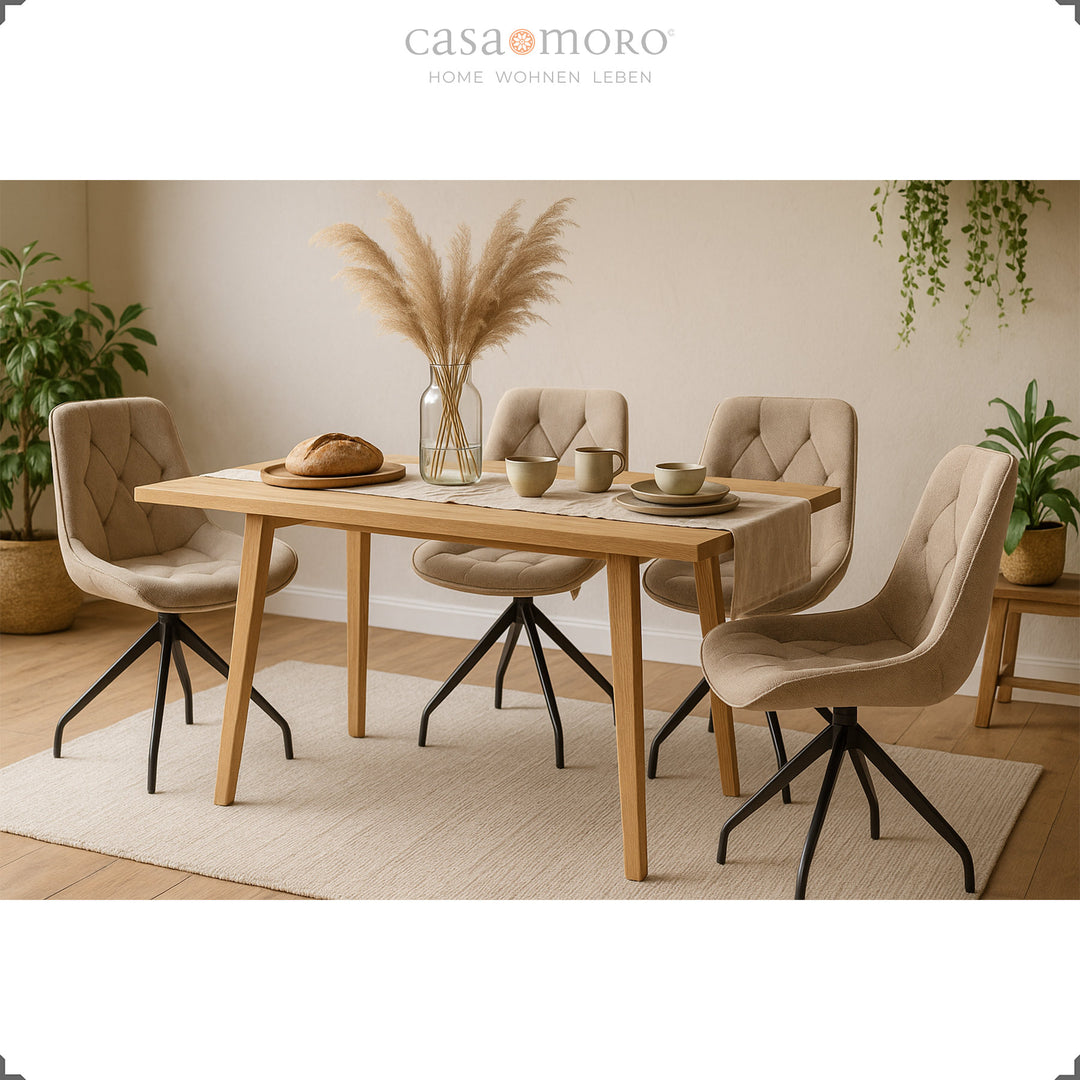 Quatro cadeiras estofadas giratórias a 360° em castanho com estrutura metálica preta – elegante zona de refeições com mesa de madeira, erva-dos-pampas e um ambiente acolhedor e natural