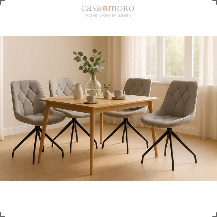 Quatro cadeiras de sala de jantar cinzentas com rotação de 360° e estrutura em metal preto – sala de jantar luminosa com mesa de madeira e decoração natural