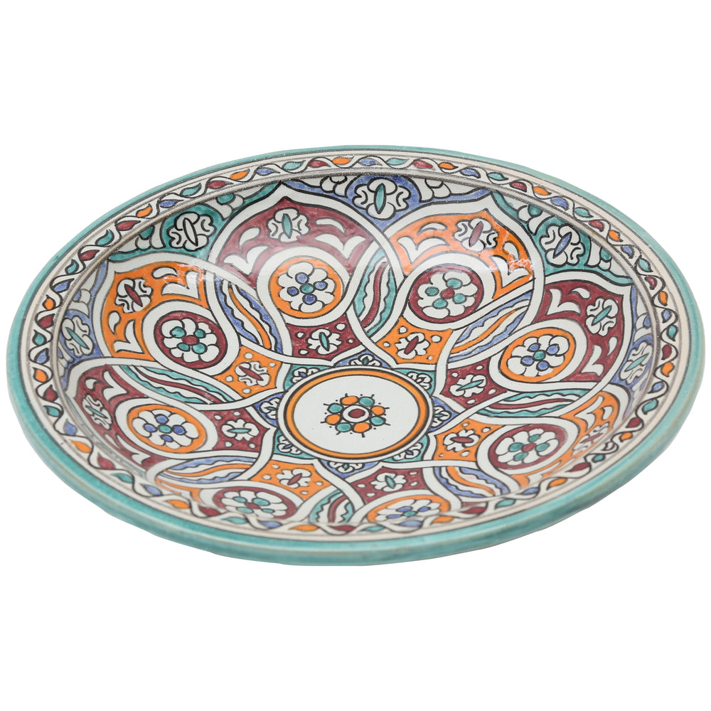 Taça de cerâmica pintada à mão com um ornamento circular entrelaçado em turquesa, laranja e vermelho bordô