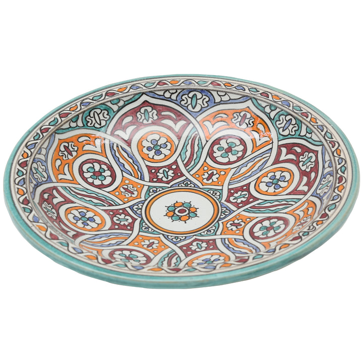Taça de cerâmica pintada à mão com um ornamento circular entrelaçado em turquesa, laranja e vermelho bordô