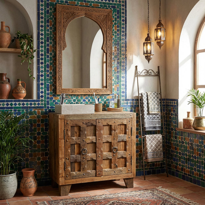 Lavatório de encaixe de formas geométricas em pedra natural clara, assente sobre um móvel de madeira, numa casa de banho de estilo oriental com azulejos de mosaico