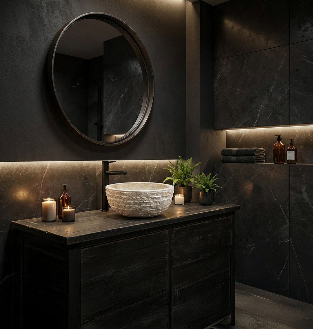 Lavatório elegante em pedra natural, montado sobre uma bancada escura, numa moderna casa de banho tipo spa à luz de velas