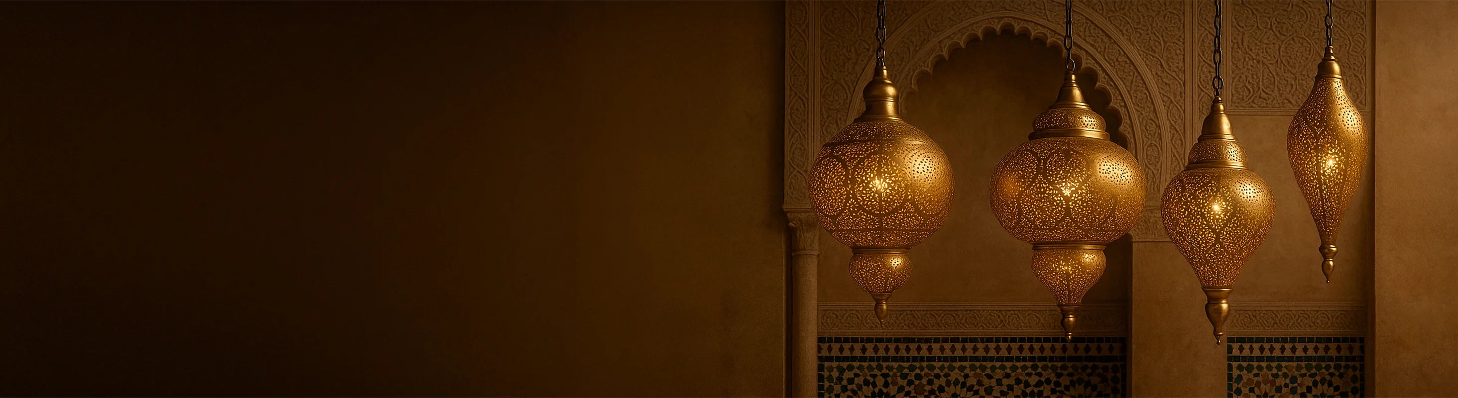 Candeeiros de teto orientais em latão – Luminárias orientais de teto de latão estão penduradas em frente a arcos ornamentados e paredes de mosaico em um interior marroquino.