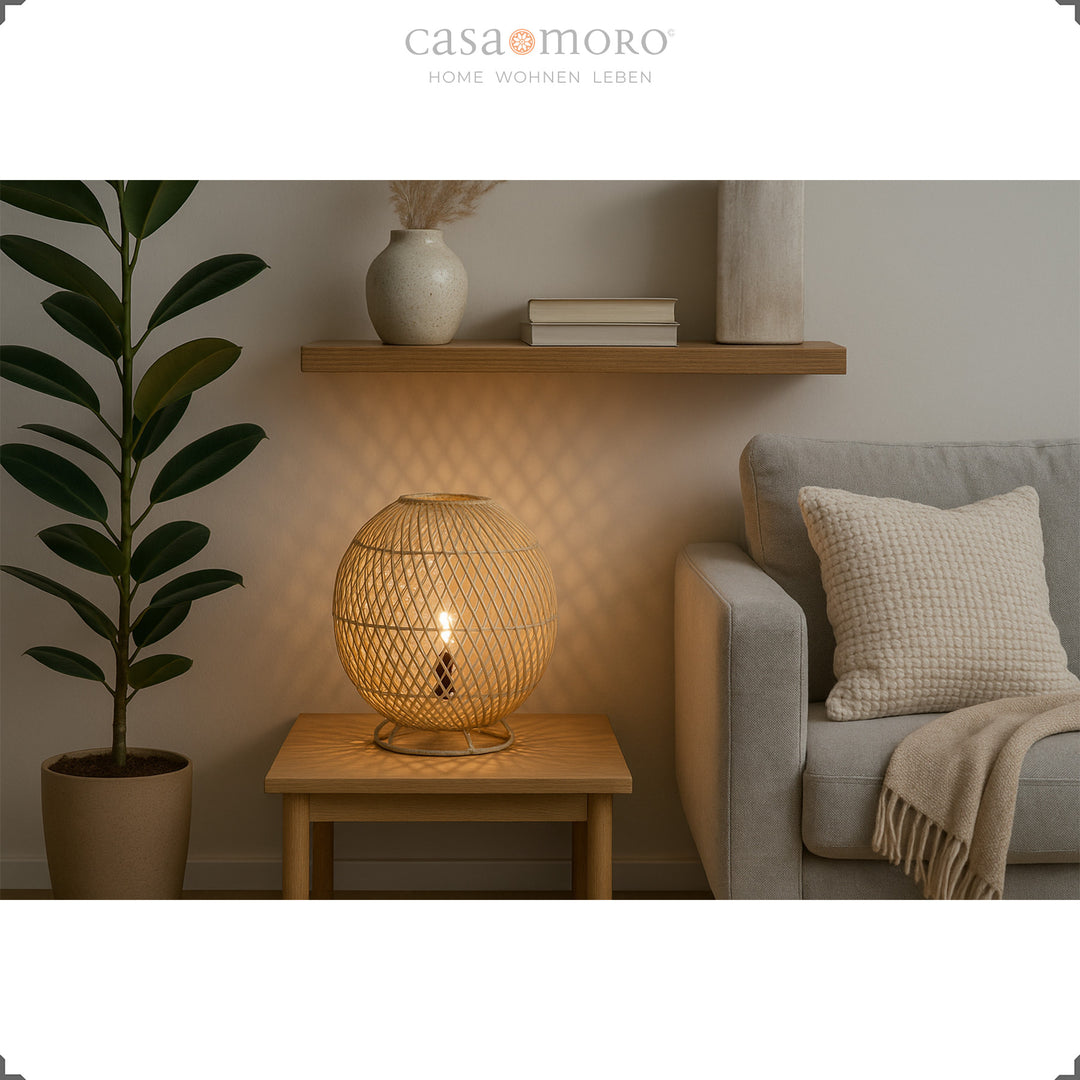 Candeeiro redondo de rattan sobre uma mesa de madeira ao lado do sofá, luz suave e decoração natural