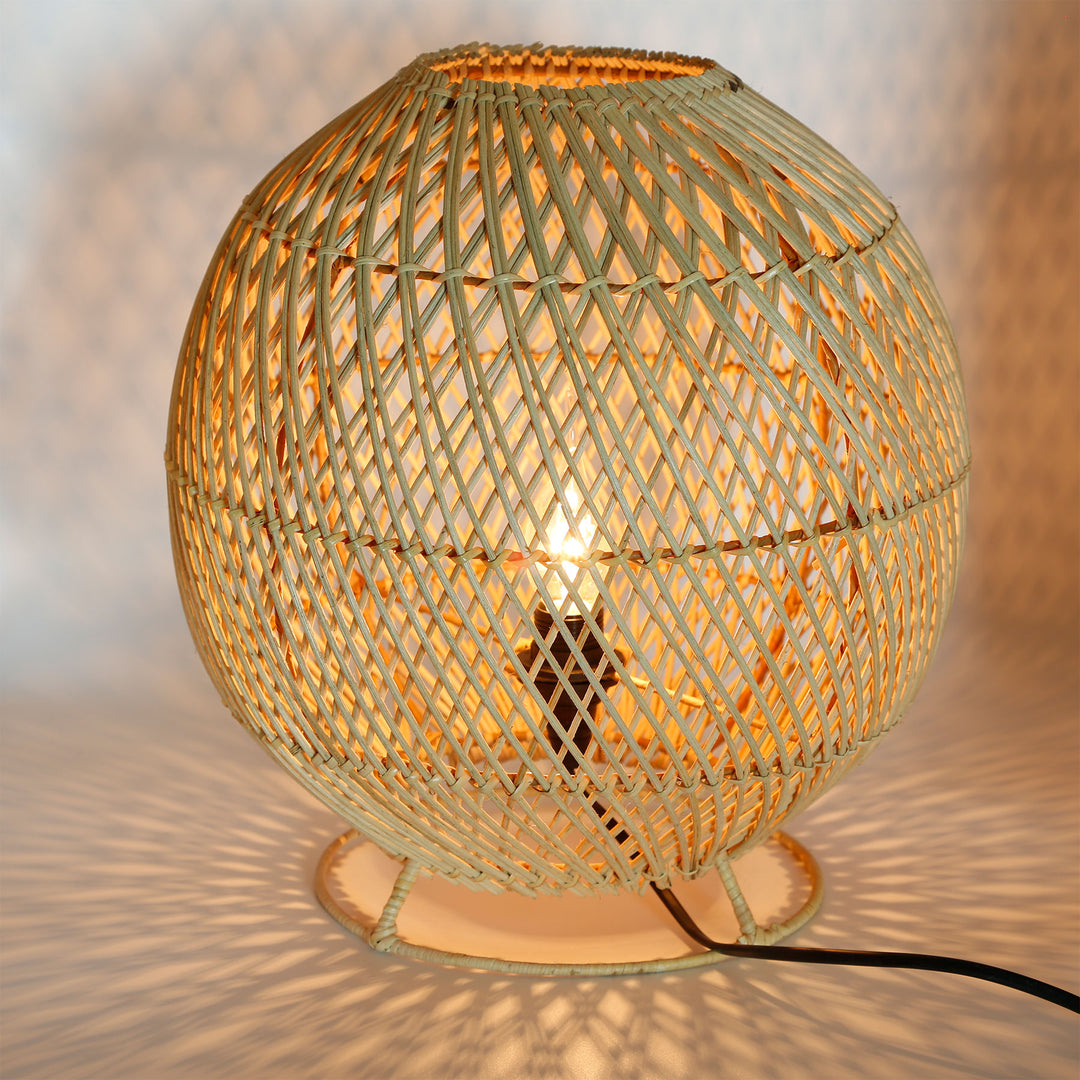 Candeeiro de pé redondo em rattan com um delicado padrão de trançado e um jogo de luzes acolhedor na parede e no chão