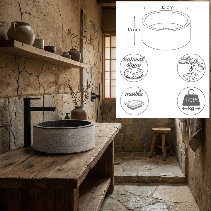 Lavatório redondo em pedra sobre uma mesa rústica de madeira, com ilustrações personalizadas e símbolos de materiais, em destaque num tranquilo espaço de banhos naturais.