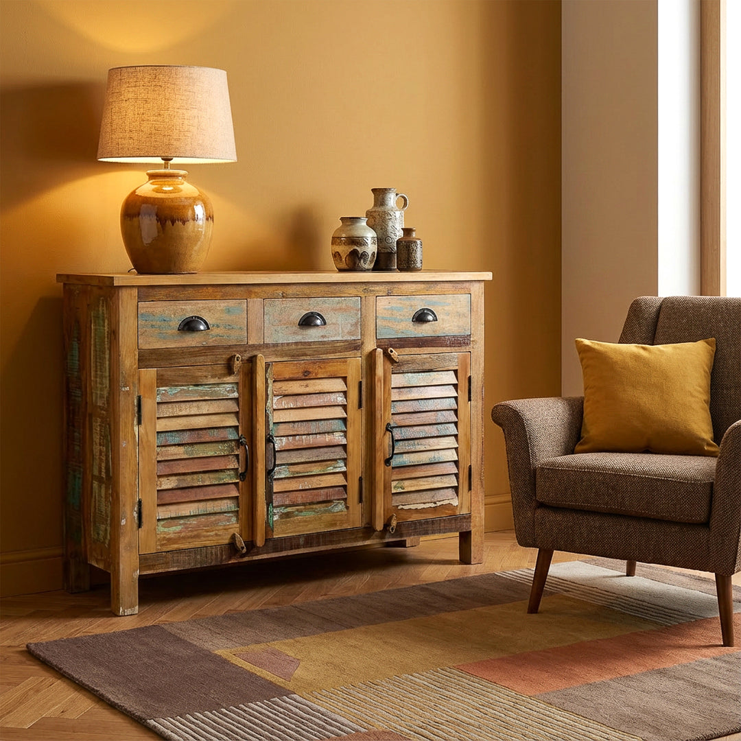 Aparador alto em madeira maciça e madeira recuperada com gavetas de estilo vintage, colocado numa sala de estar moderna