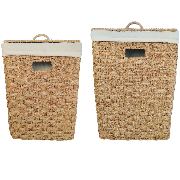 Cestos de roupa suja retangulares em erva-do-mar, em conjunto de 2 unidades, com capacidades de aproximadamente 55 e 85 litros, com tampas fechadas e inserções em tecido de cor clara.