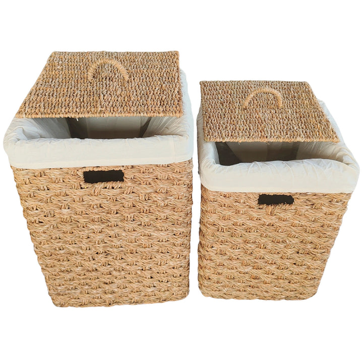 Cestos de roupa suja retangulares em erva-do-mar, em conjunto de 2 unidades, com capacidade de cerca de 55 e 85 litros, com tampas salientes e inserções em tecido de cor clara.