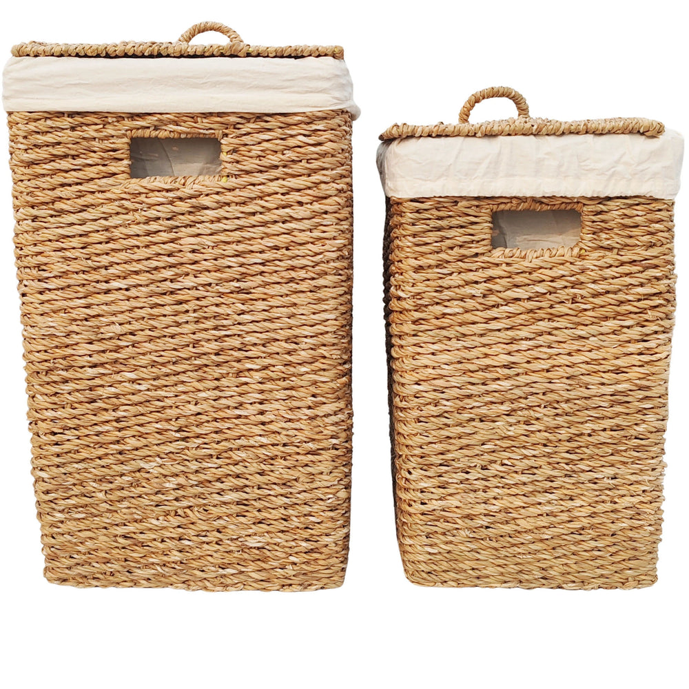 Conjunto de cestos para roupa suja em erva marinha, com capacidades de 50 e 90 litros, tampas fechadas, alças e inserções em tecido de cor clara.