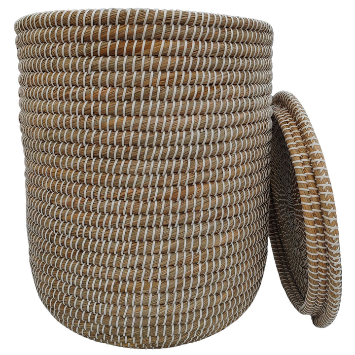 Cesto de roupa suja aberto, em erva-do-mar, nas cores natural/branco, com um volume de cerca de 65 litros e tampa encostada lateralmente.