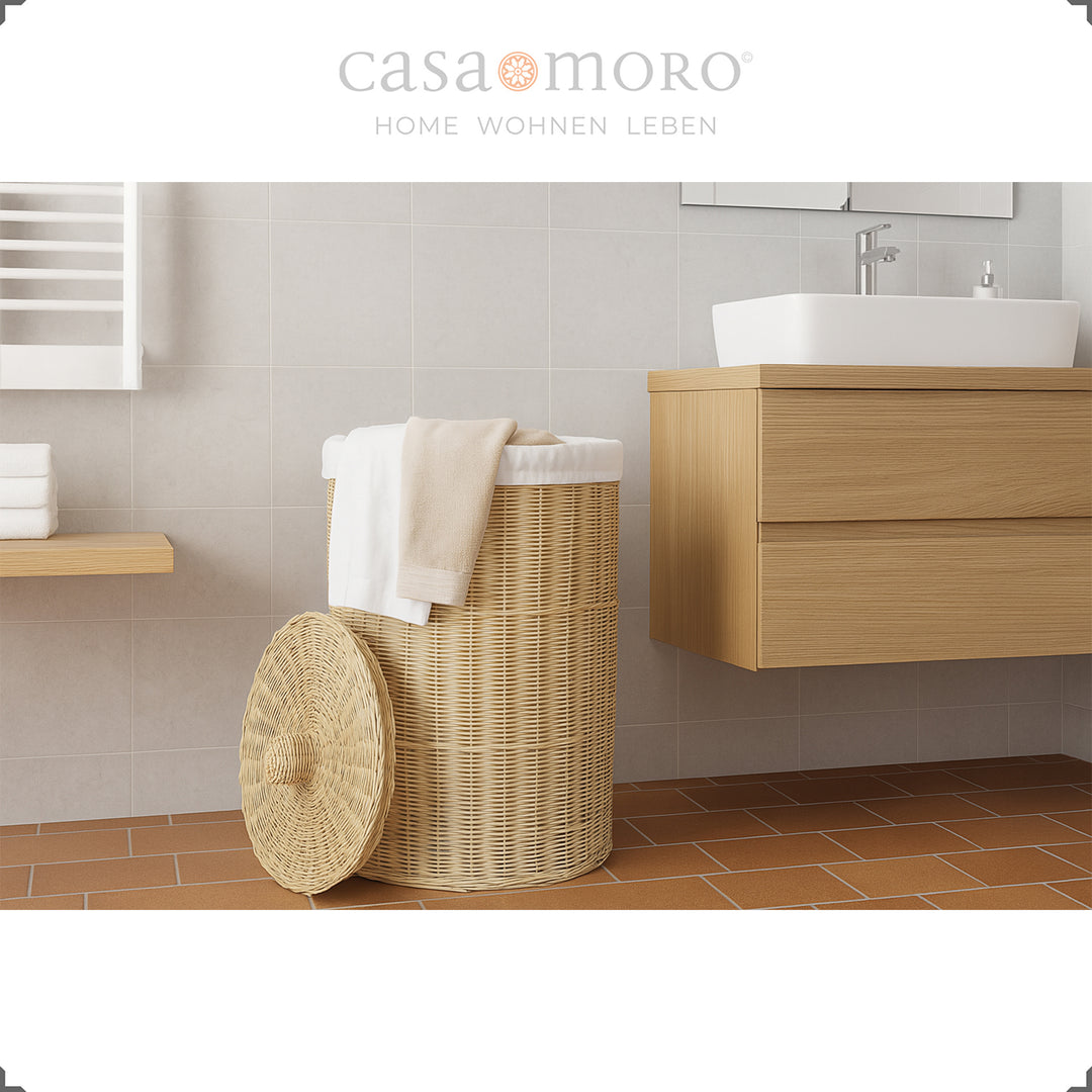 Cesto de roupa suja trançado em cor natural com tampa, decorado com uma toalha branca na casa de banho